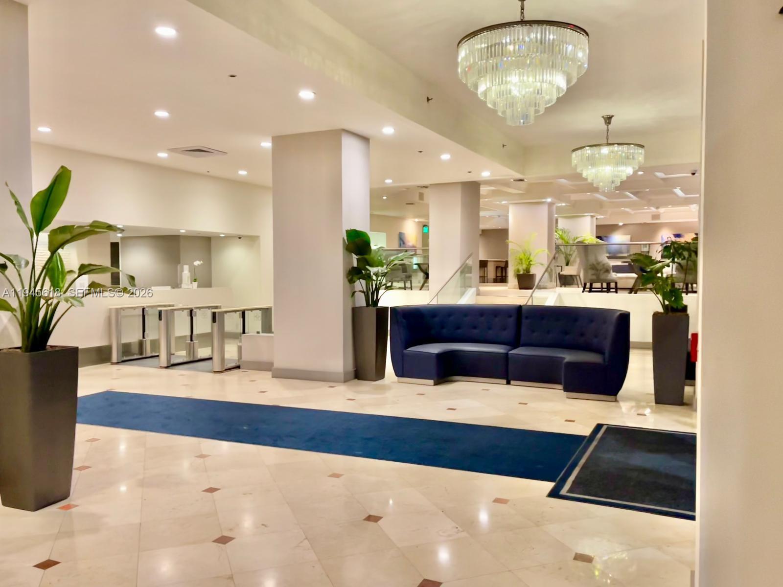 100 Lincoln Road, Unit 503 Miami Beach, FL 33139 - Photo 23 of 25 a living room with kitchen island furniture and a chandelier