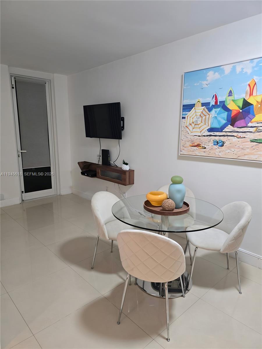 100 Lincoln Road, Unit 503 Miami Beach, FL 33139 - Photo 8 of 25 a dining room with furniture and a flat screen tv
