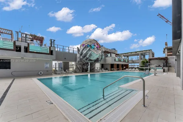 a swimming pool view with a seating space