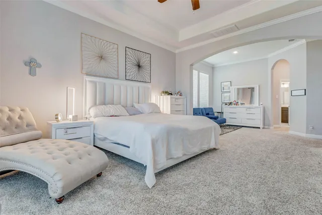 a bedroom with a bed a mirror and lamp