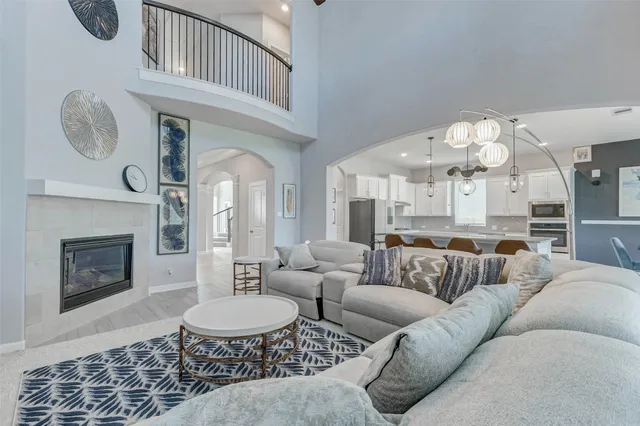 a living room with furniture a fireplace and a chandelier