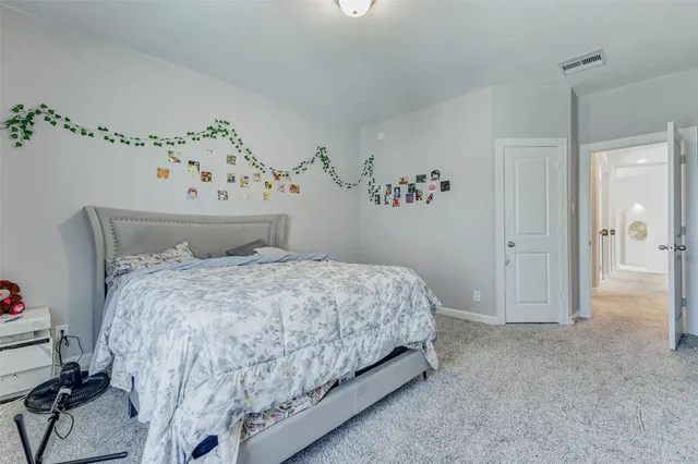 a bed sitting in a bedroom and painting on the wall