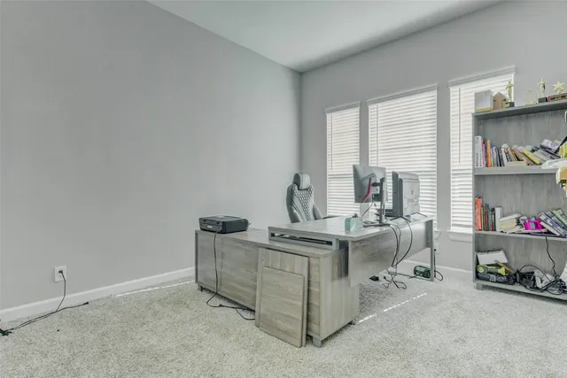 a view of a workspace with furniture and a window