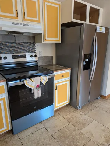 a kitchen with stainless steel appliances granite countertop a refrigerator and a stove