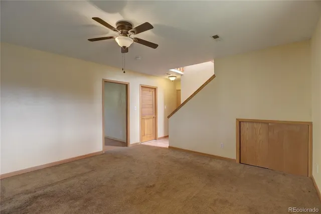 a view of an empty room with a ceiling fan