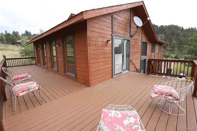 a balcony with wooden floor table and chairs