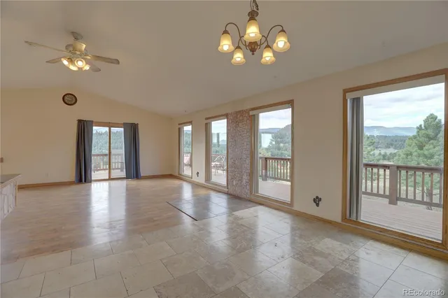 a view of an empty room with a window and chandelier