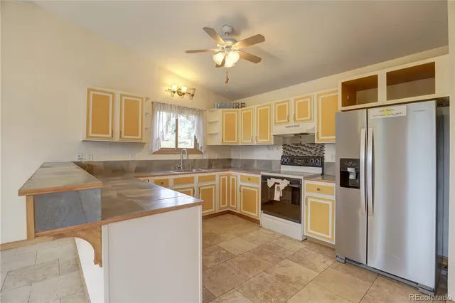 a kitchen with stainless steel appliances granite countertop a refrigerator a stove a sink and a microwave