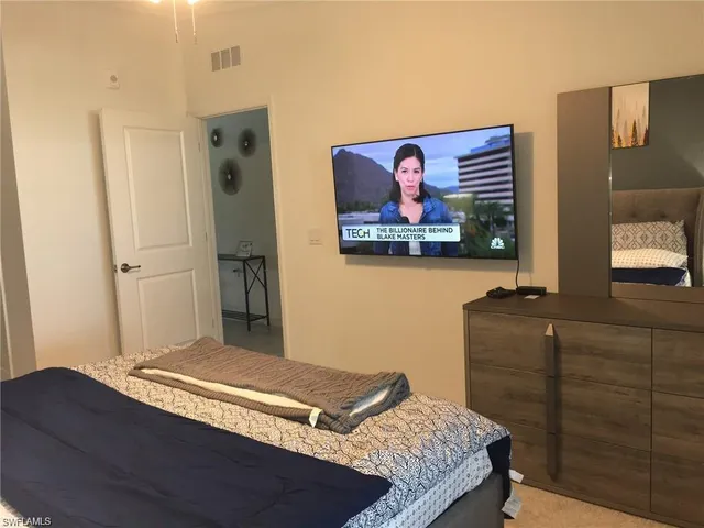 a bedroom with a bed and painting on the wall