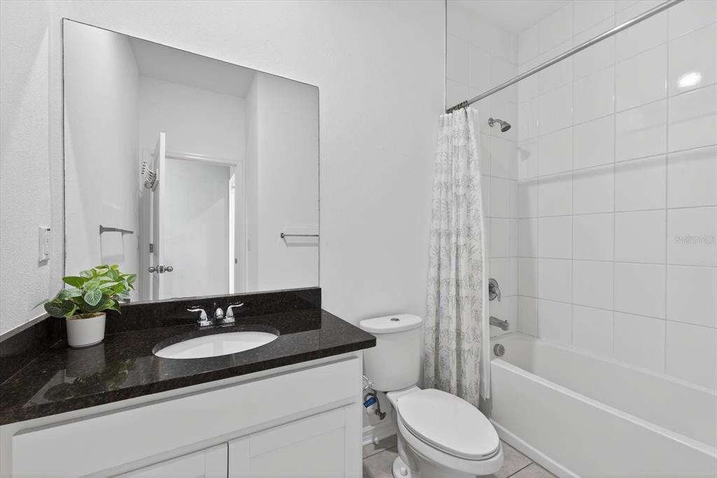 11883 Brighton Knoll Loop Riverview, FL 33579 - Photo 14 of 45 a bathroom with a granite countertop sink a toilet mirror and shower