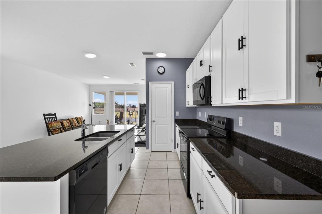11883 Brighton Knoll Loop Riverview, FL 33579 - Photo 3 of 45 a kitchen with granite countertop a sink and cabinets