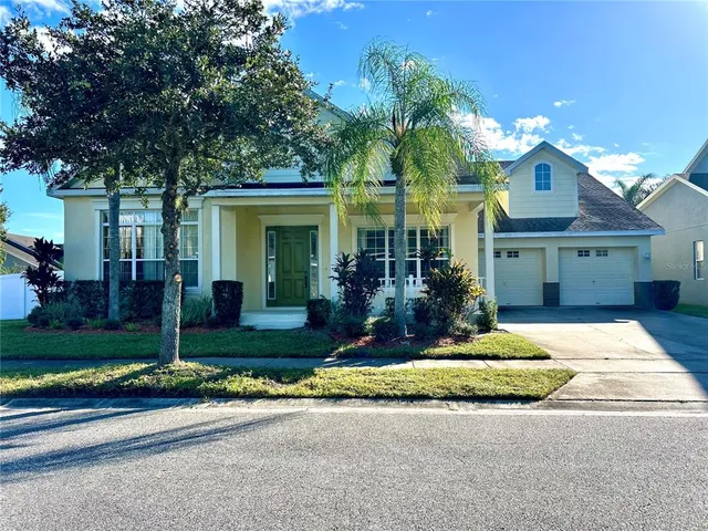 a front view of a house with a yard and potted plants