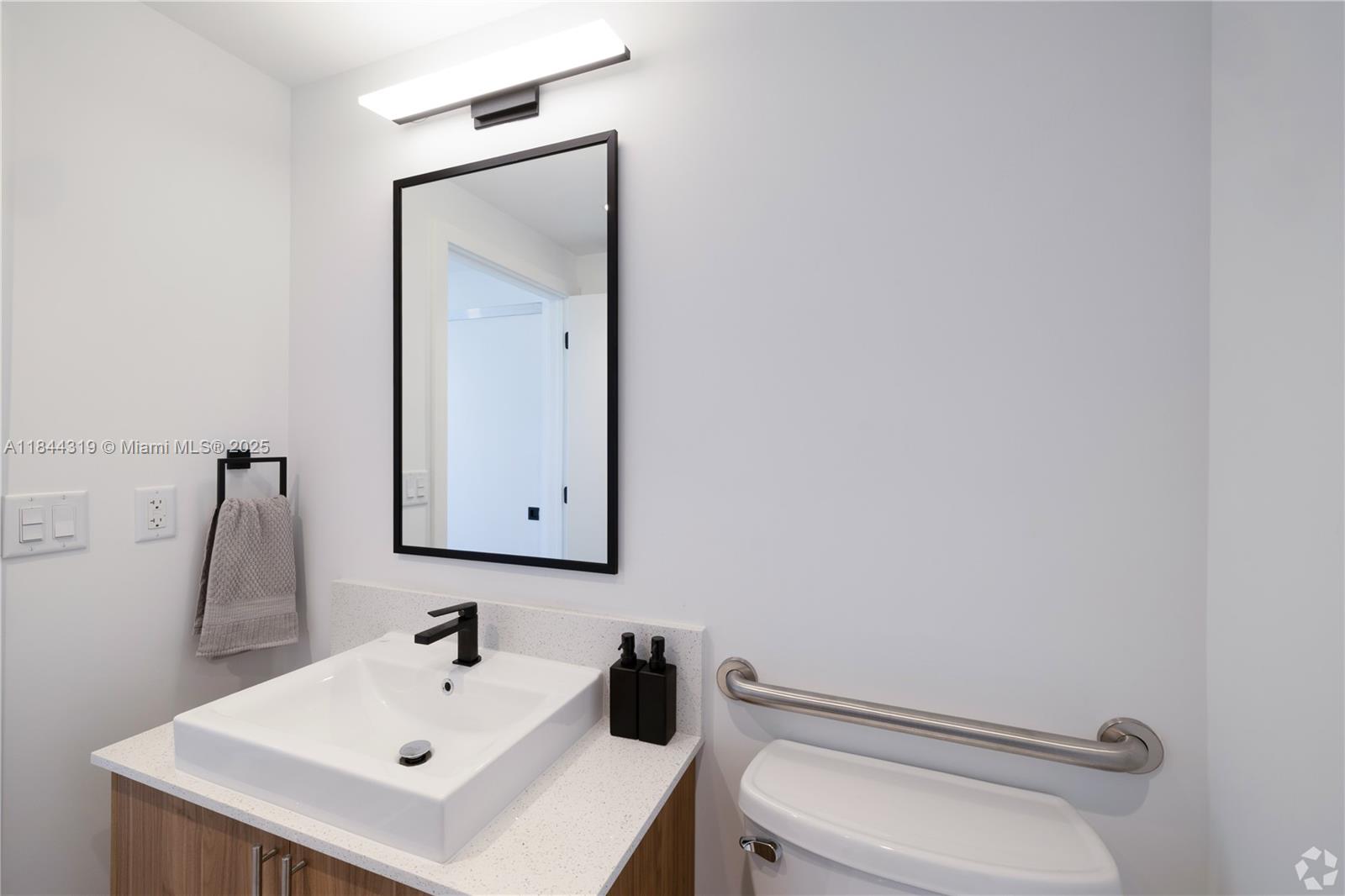 650 Southwest 1st Street, Unit 205 Miami, FL 33130 - Photo 5 of 15 a bathroom with a toilet sink and mirror