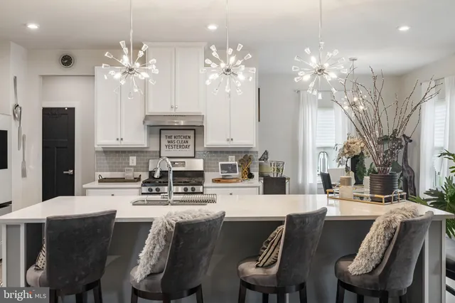 a dinning room with stainless steel appliances kitchen island a chandelier dining table and chairs