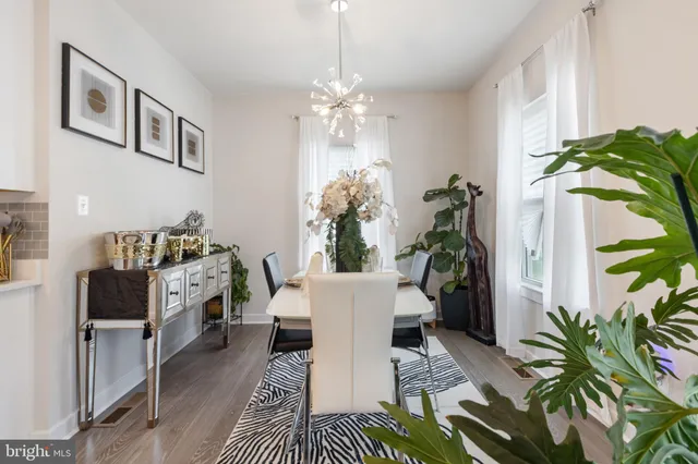a dining room with furniture potted plants and wooden floor