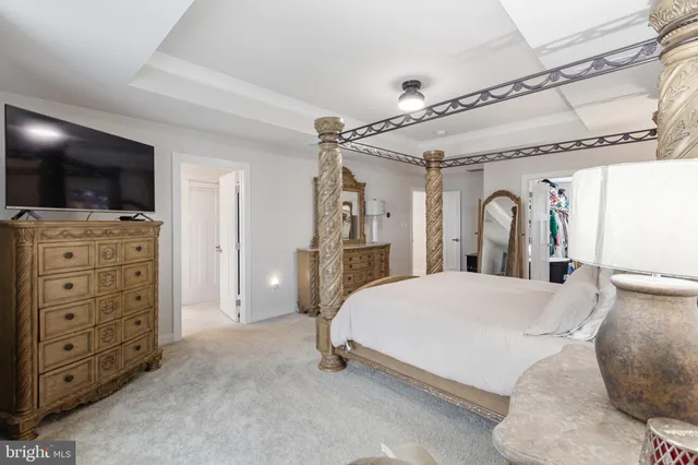 a spacious bedroom with a bed and a flat screen tv