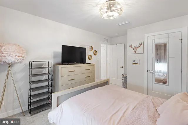 a bedroom with a bed and a flat tv screen tv on the dresser