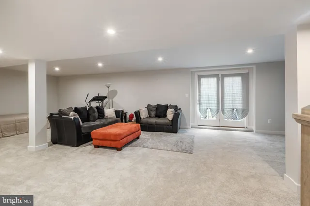 a living room with furniture a flat screen tv and a large window