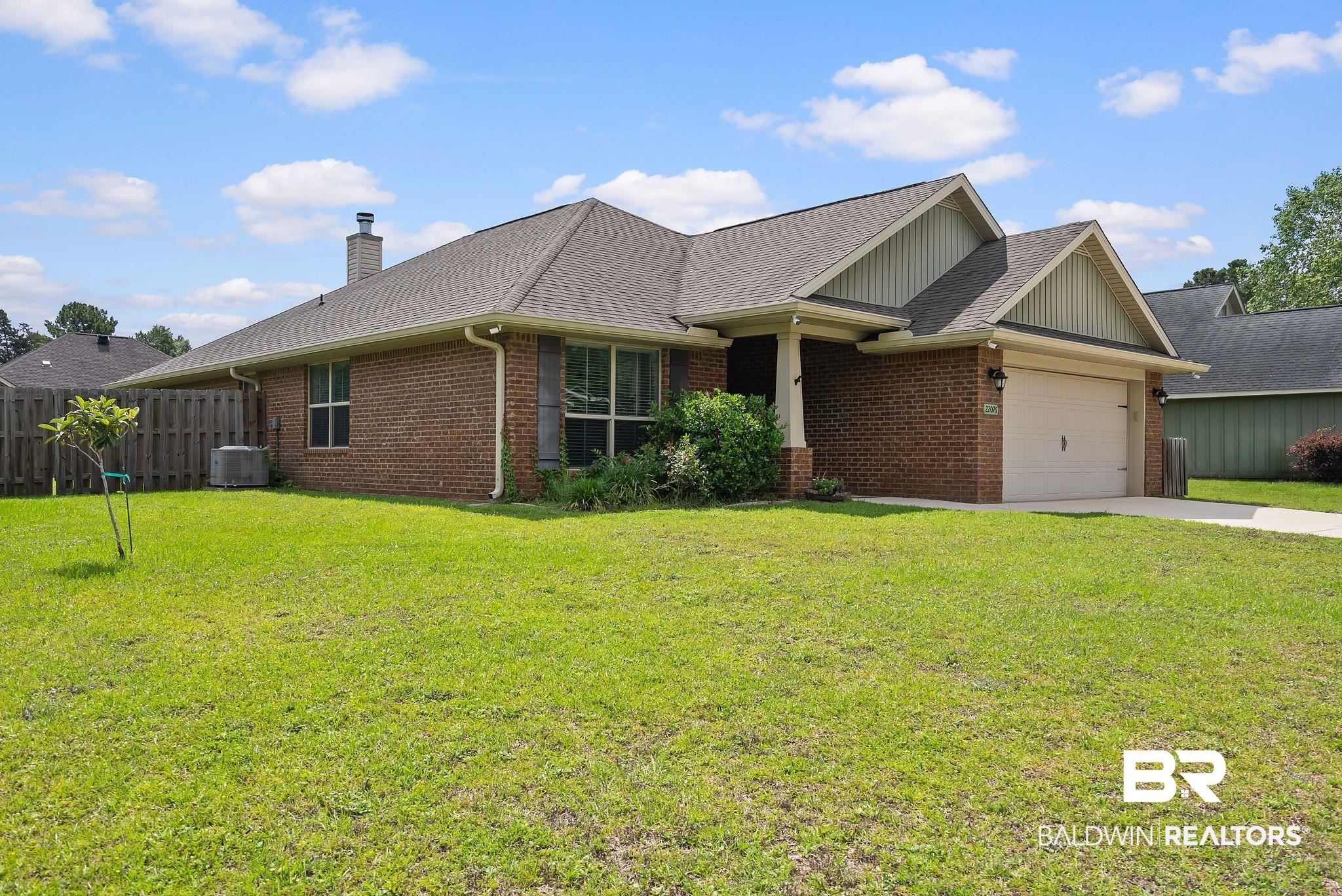 22076 Garland Loop Silverhill, AL 36576 - Photo 2 of 27 Brick exterior featuring a two-car garage with a paved driveway, multiple gabled rooflines, and a covered entry porch