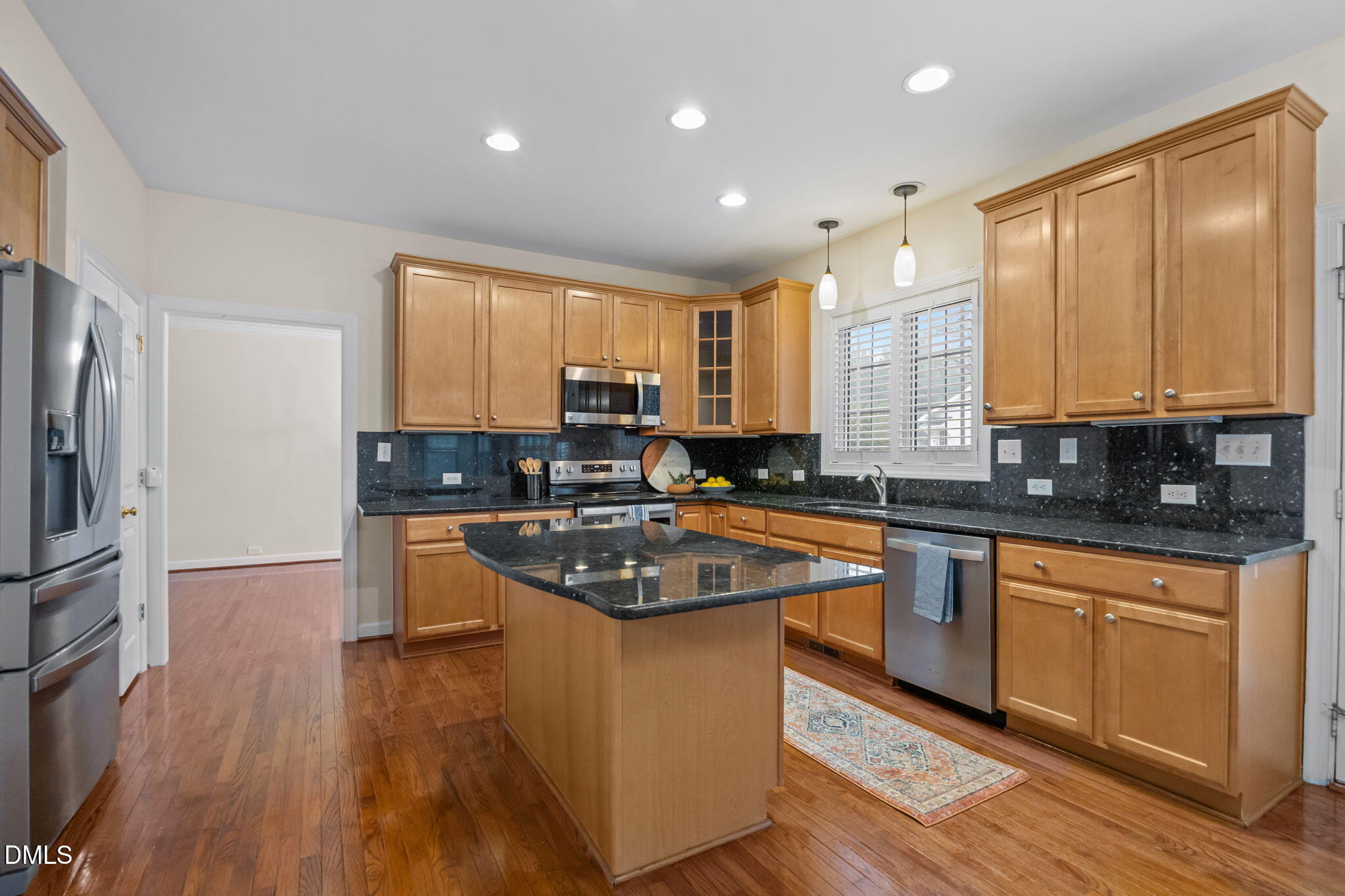 7 Bobcat Court Durham, NC 27713 - Photo 20 of 64 a kitchen with stainless steel appliances granite countertop wooden cabinets a refrigerator a sink a stove a microwave and wooden floors