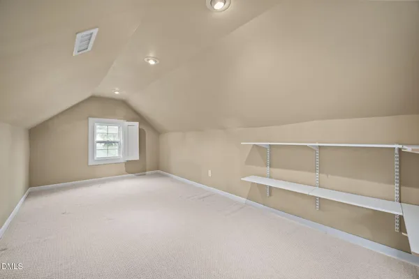 an empty room with chandelier fan and windows