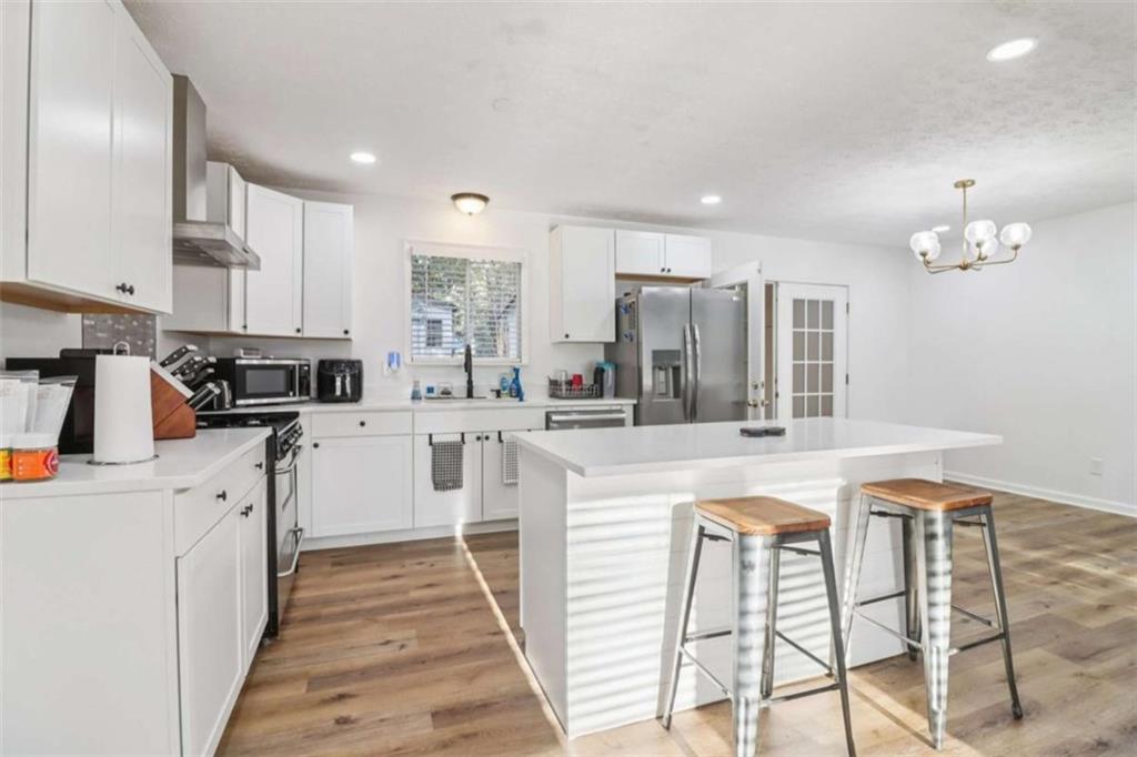 9202 Settlers Grove Road Northeast Covington, GA 30014 - Photo 13 of 45 a kitchen with stainless steel appliances kitchen island granite countertop a sink and cabinets