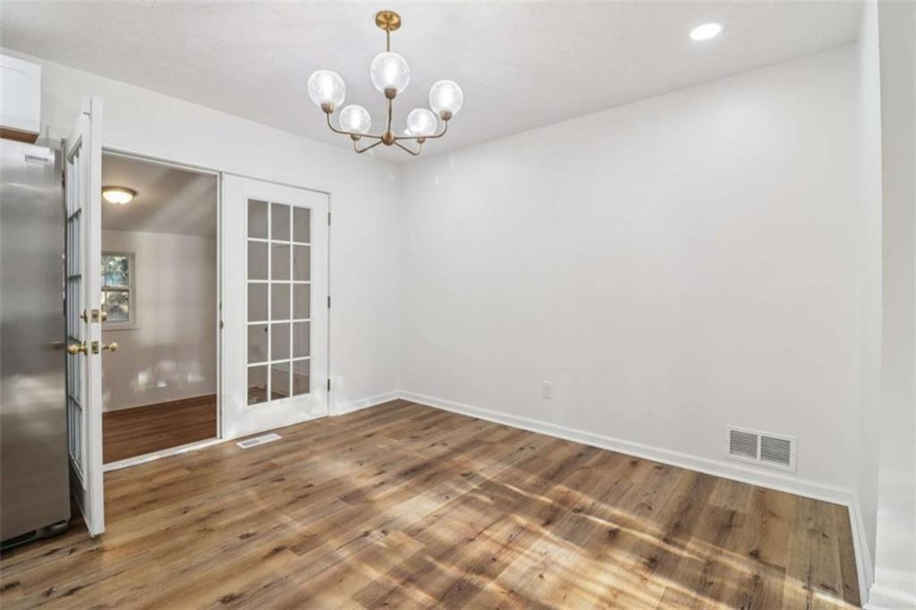 9202 Settlers Grove Road Northeast Covington, GA 30014 - Photo 9 of 45 an empty room with wooden floor and windows