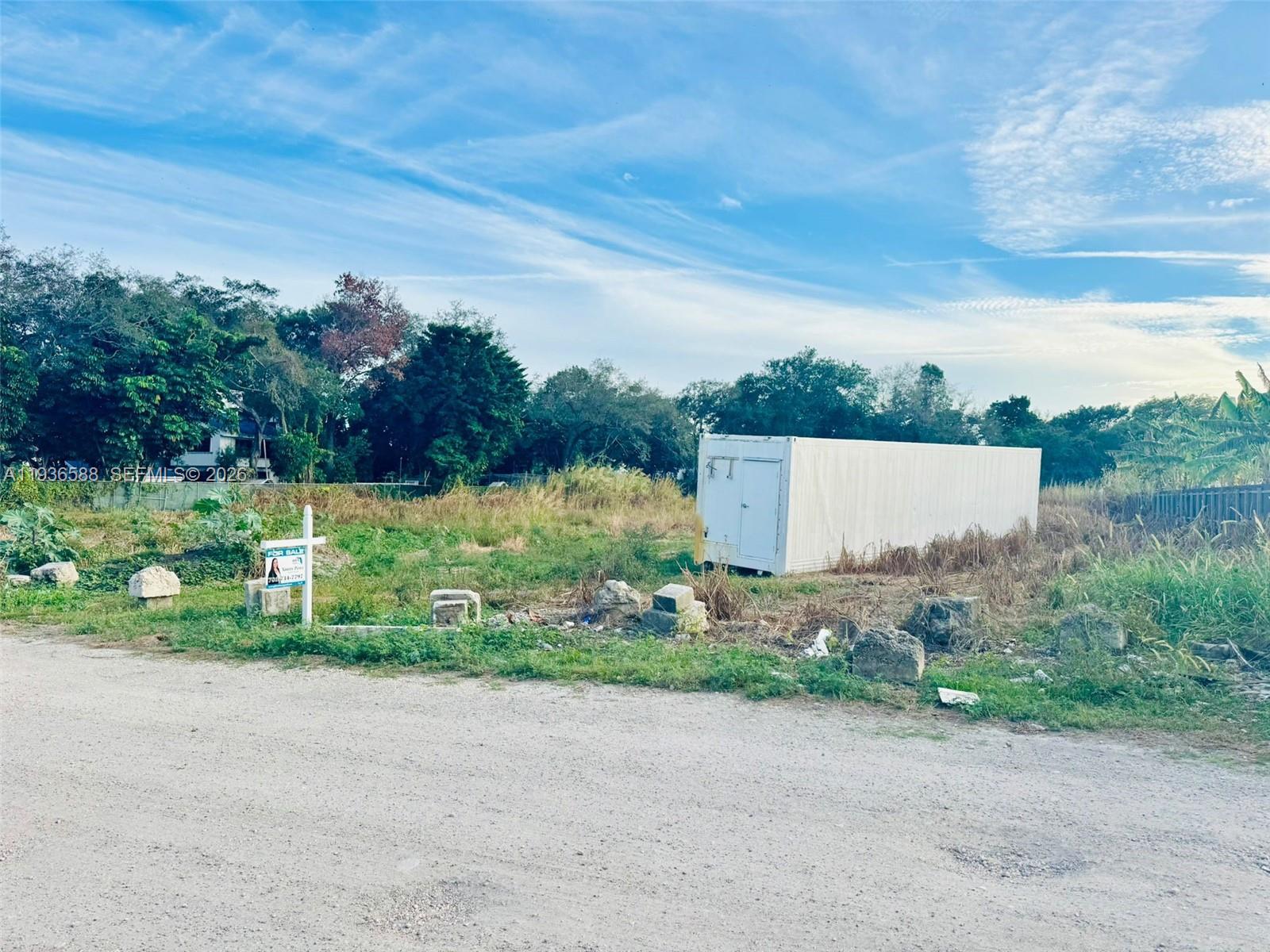 12330 Southwest 240th Street Homestead, FL 33032 - Photo 2 of 5 front view of a house with a yard and a lake view