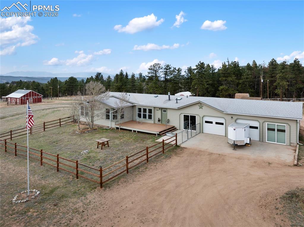585 Mills Ranch Road Woodland Park, CO 80863 - Photo 2 of 46 Ranch-style home featuring driveway, an attached garage, and an outbuilding