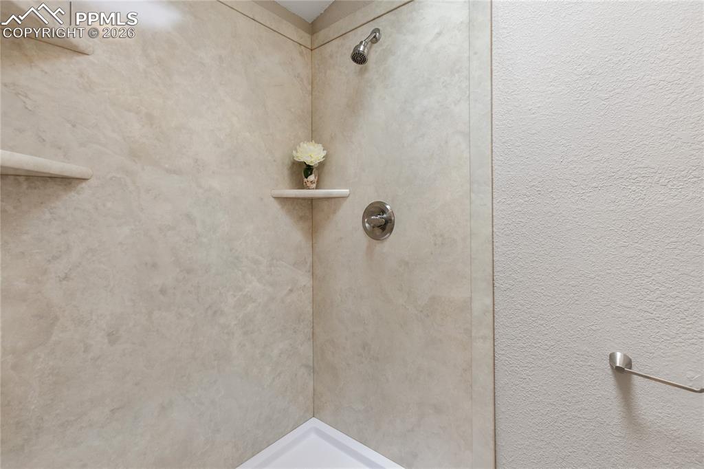 585 Mills Ranch Road Woodland Park, CO 80863 - Photo 37 of 46 Full bathroom featuring a stall shower and a textured wall
