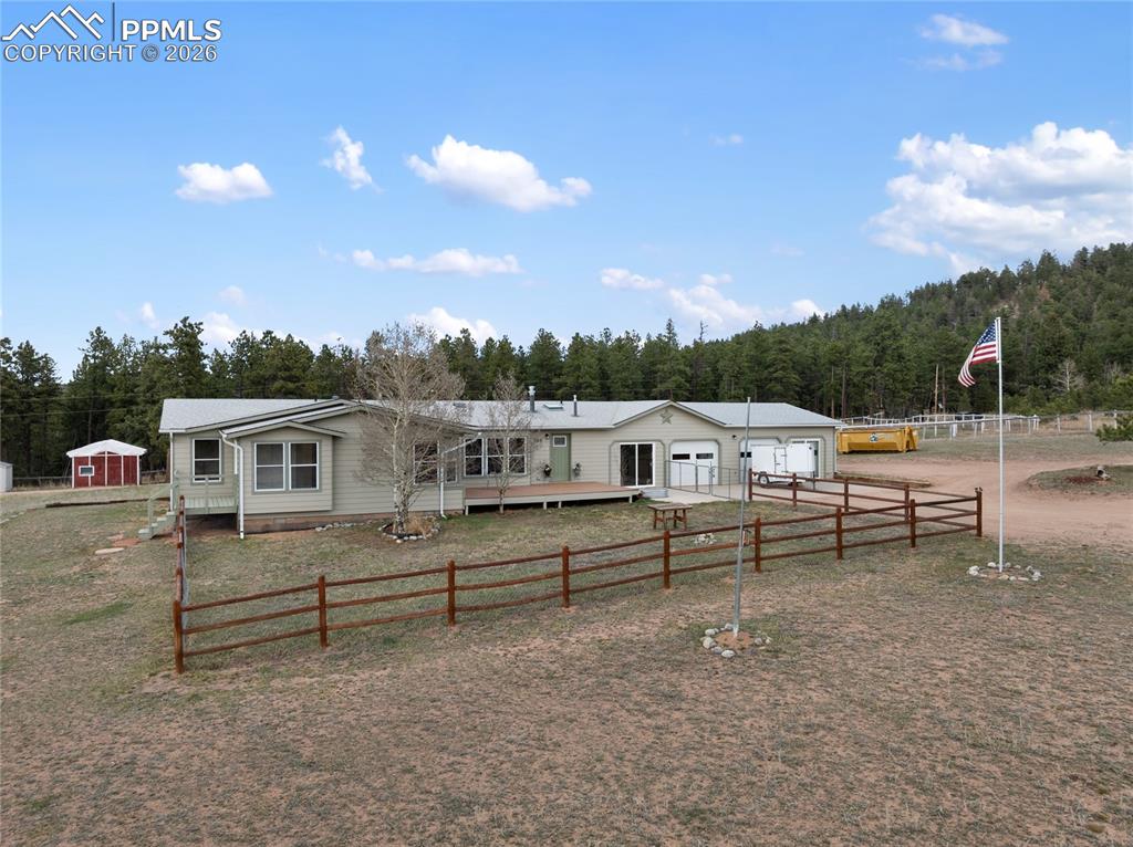 585 Mills Ranch Road Woodland Park, CO 80863 - Photo 4 of 46 View of front of house with a garage, a fenced front yard, and driveway