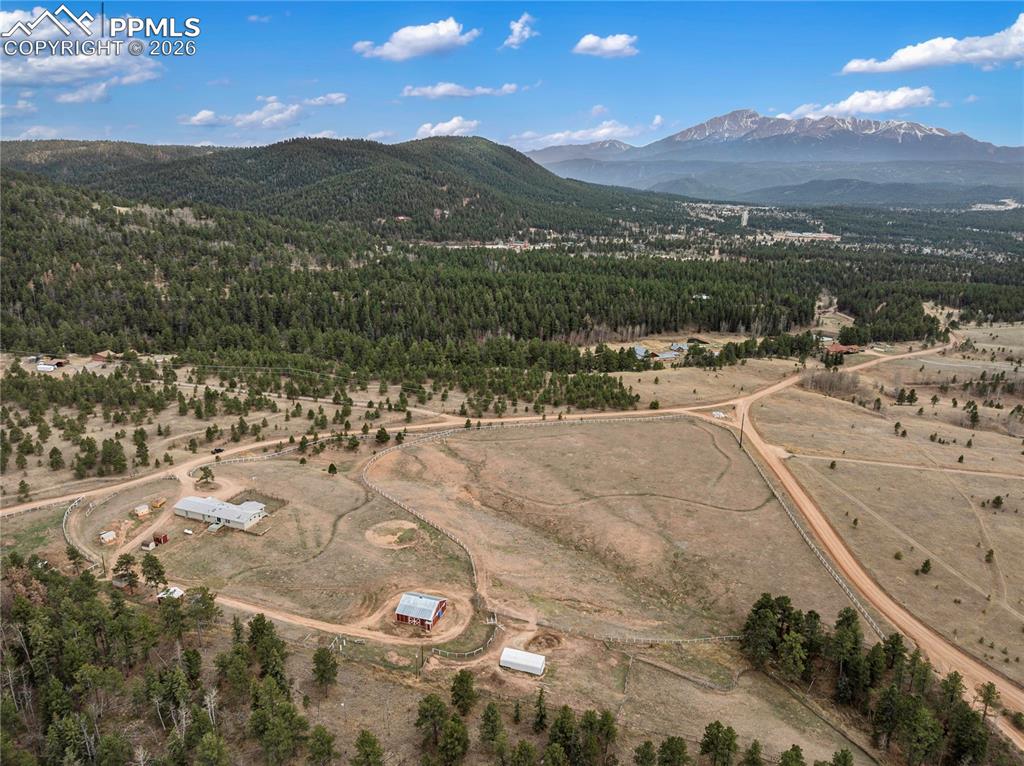 585 Mills Ranch Road Woodland Park, CO 80863 - Photo 10 of 46 Aerial view of sparsely populated area featuring a mountain backdrop and a heavily wooded area
