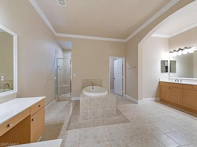 a spacious bathroom with a double vanity sink a large mirror and a shower