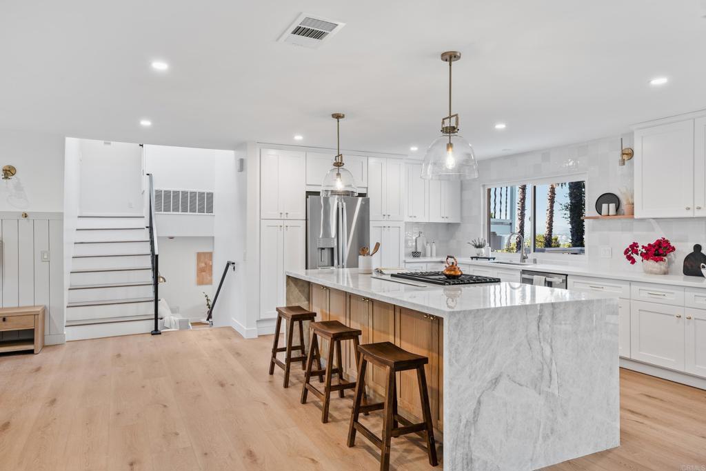 1608 Towell Lane Escondido, CA 92029 - Photo 4 of 35 a kitchen with kitchen island a stove a table and chairs in it