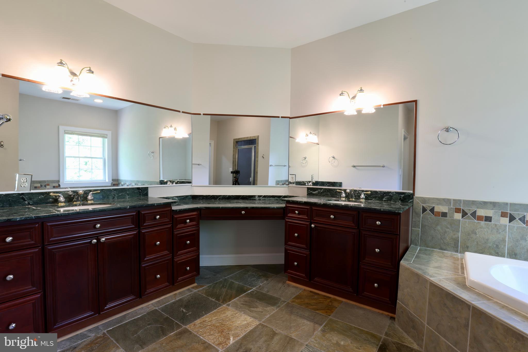 1310 Forestwood Drive McLean, VA 22101 - Photo 36 of 55 a large bathroom with a granite countertop double vanity sink a mirror and a bathtub