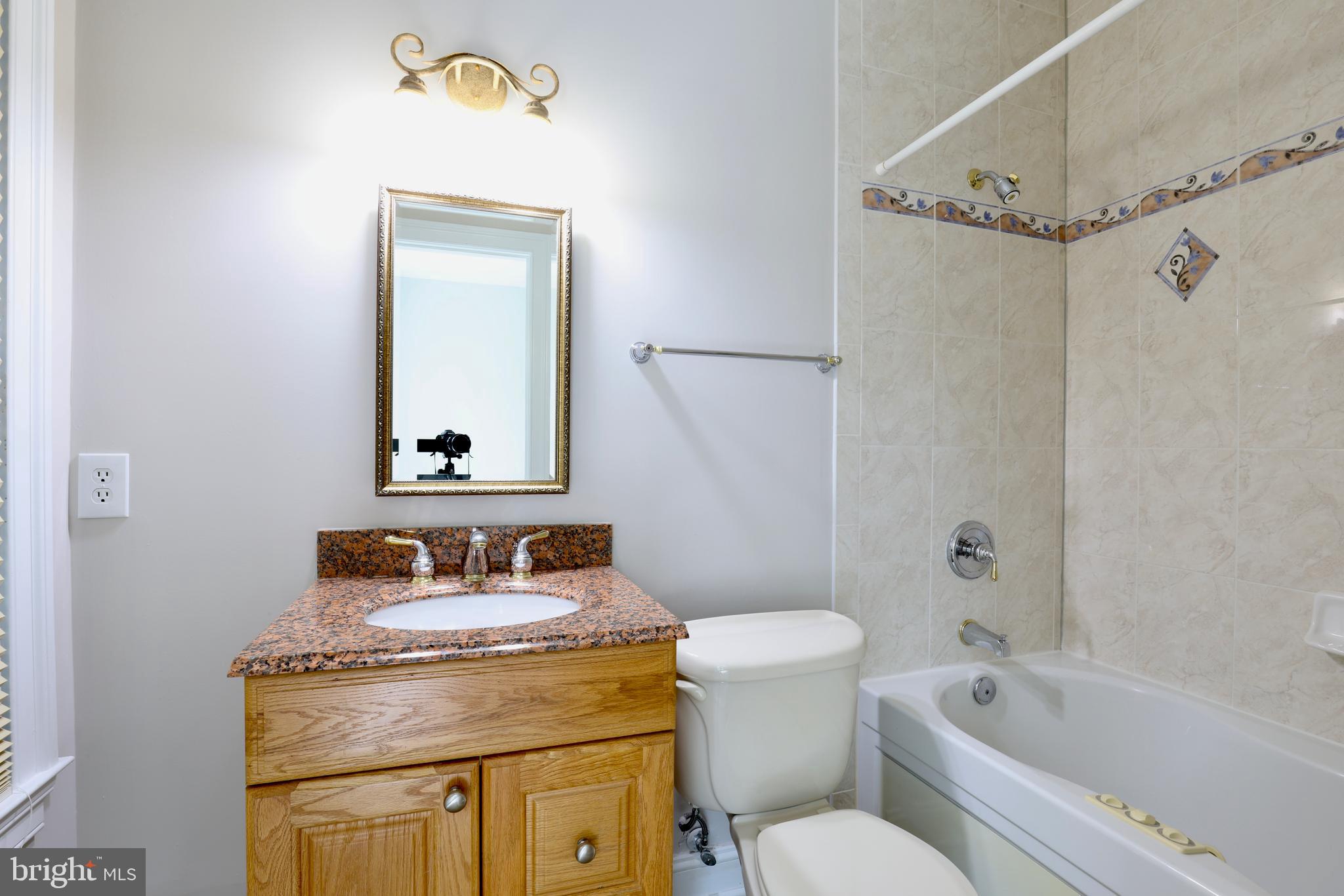 1310 Forestwood Drive McLean, VA 22101 - Photo 42 of 55 a bathroom with a granite countertop toilet sink and mirror