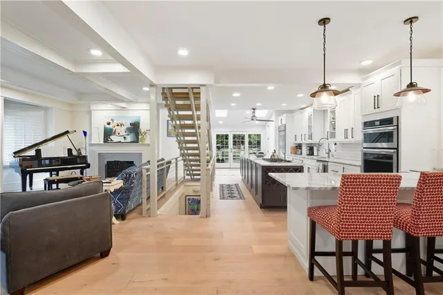 a large white kitchen with stainless steel appliances kitchen island granite countertop a large counter top space and cabinets