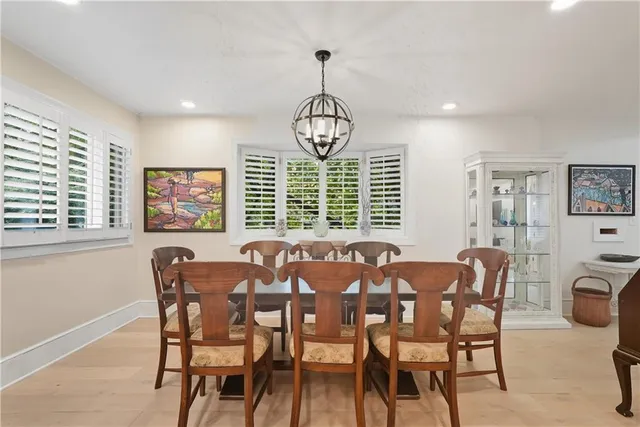 a large dining room with furniture a chandelier and window
