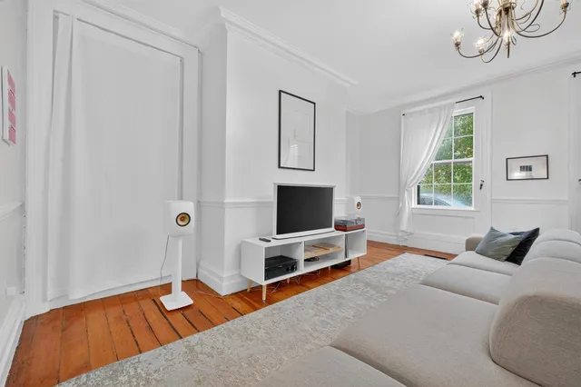 a living room with furniture a window and a chandelier