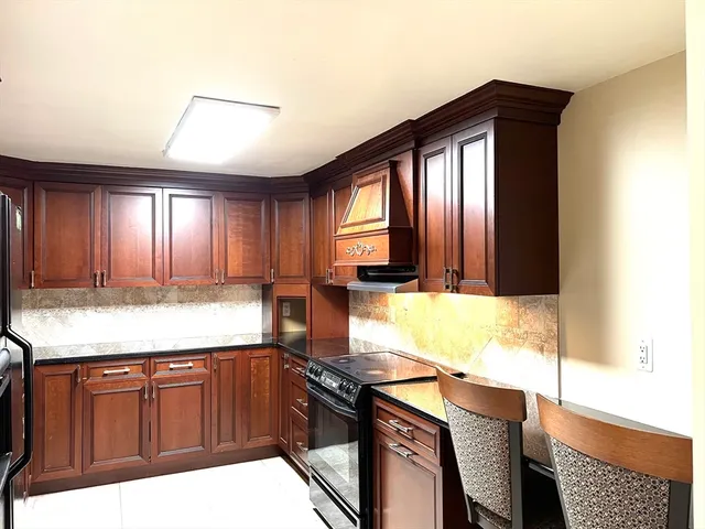 a kitchen with granite countertop wooden cabinets a sink and dishwasher