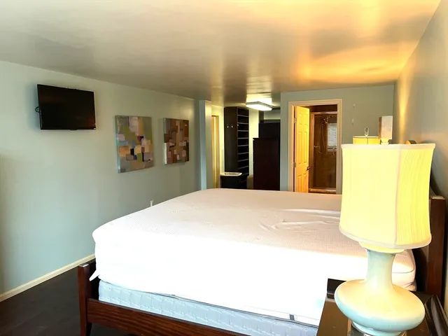 a bedroom with a bed and wooden floor