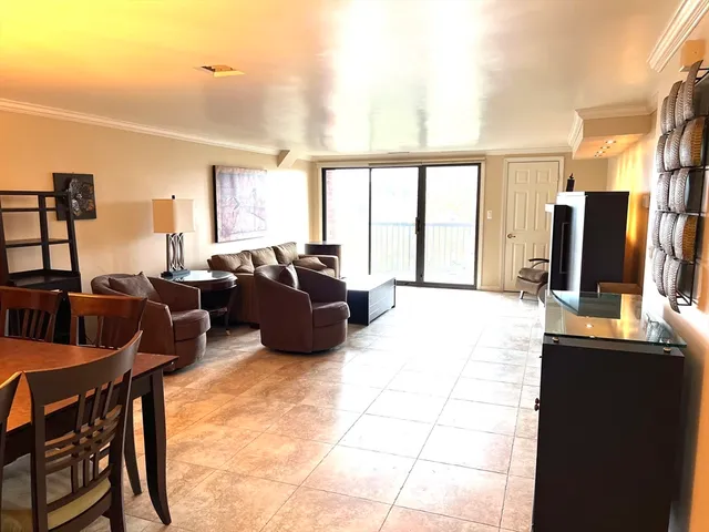 a living room with furniture a large window and a flat screen tv