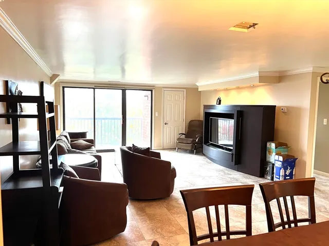 a living room with furniture a flat screen tv and floor to ceiling window