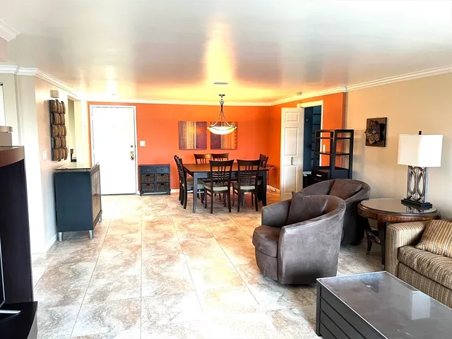 a living room with furniture a chandelier and a dining table