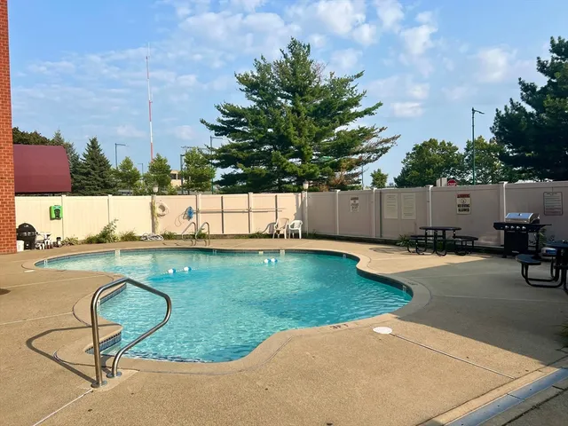 a view of a backyard with swimming pool and furniture