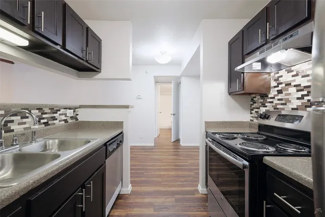 a kitchen with stainless steel appliances granite countertop a sink and a stove