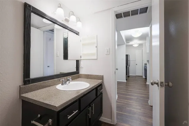 a bathroom with a sink vanity granite and a mirror