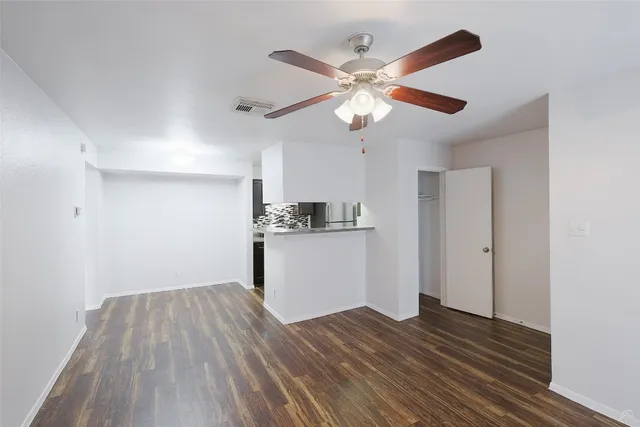 a view of a kitchen with wooden floor and a ceiling fan