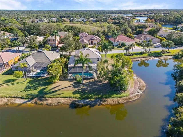 an aerial view of residential houses with outdoor space and lake view