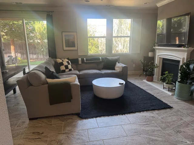 a living room with furniture a large window and a fireplace
